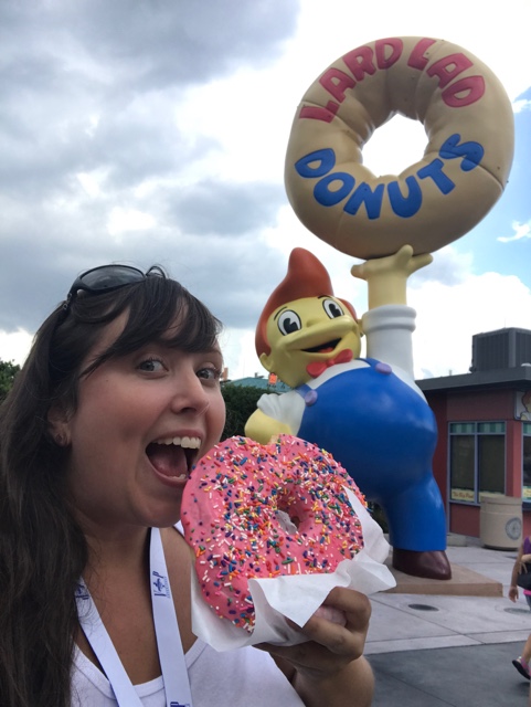 cailin eating the simpsons big pink doughnut at Universal Orlando -Universal Orlando's Best Theme Park Foods