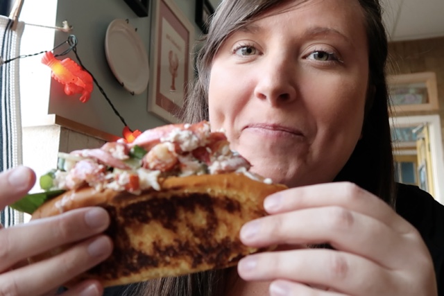 cailin eating a lobster roll at captain kats lobster shack