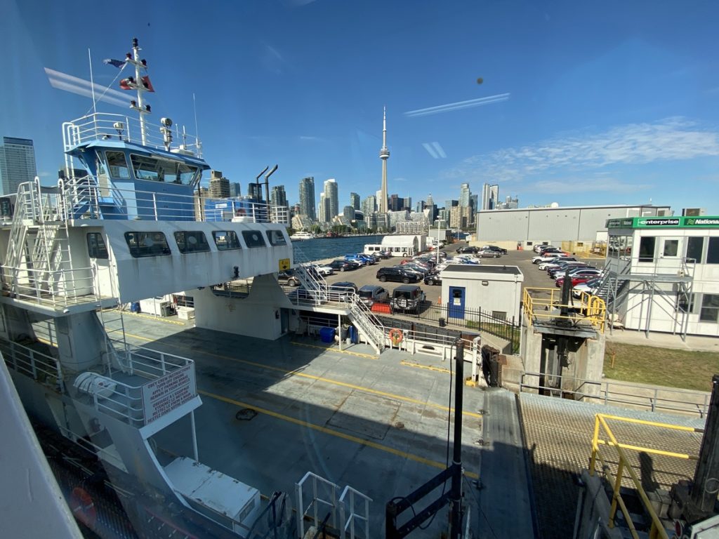 the view of ferry and the toronto skyline with the cn tower from the billy bishop airport with porter airlines